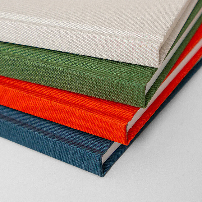 Dos des carnets rouge, vert, beige et bleu Dos des carnets rouge, vert, beige et bleu